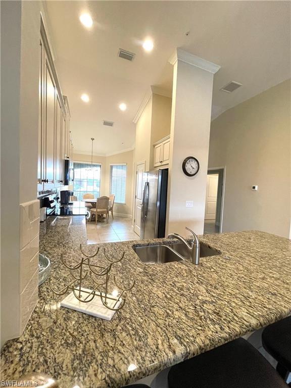 9426 Benvenuto Court, Unit 203 Naples, FL 34119 - Photo 16 of 42 a large kitchen with a table and chairs