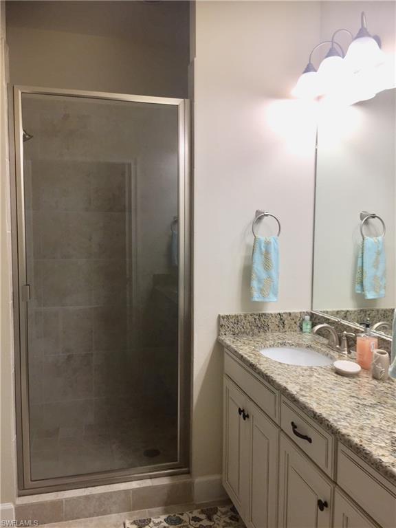9426 Benvenuto Court, Unit 203 Naples, FL 34119 - Photo 19 of 42 a bathroom with a granite countertop sink and a mirror