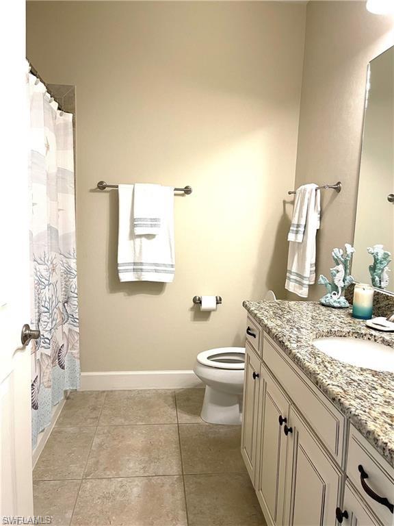 9426 Benvenuto Court, Unit 203 Naples, FL 34119 - Photo 20 of 42 a bathroom with a granite countertop sink a toilet and a mirror