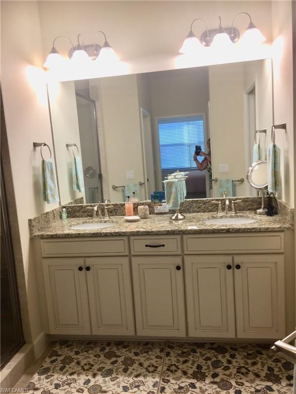 9426 Benvenuto Court, Unit 203 Naples, FL 34119 - Photo 25 of 42 a bathroom with a sink and a mirror