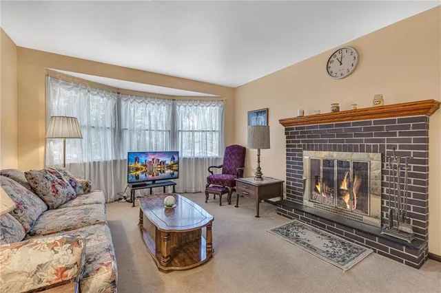 a living room with furniture a fireplace and a window