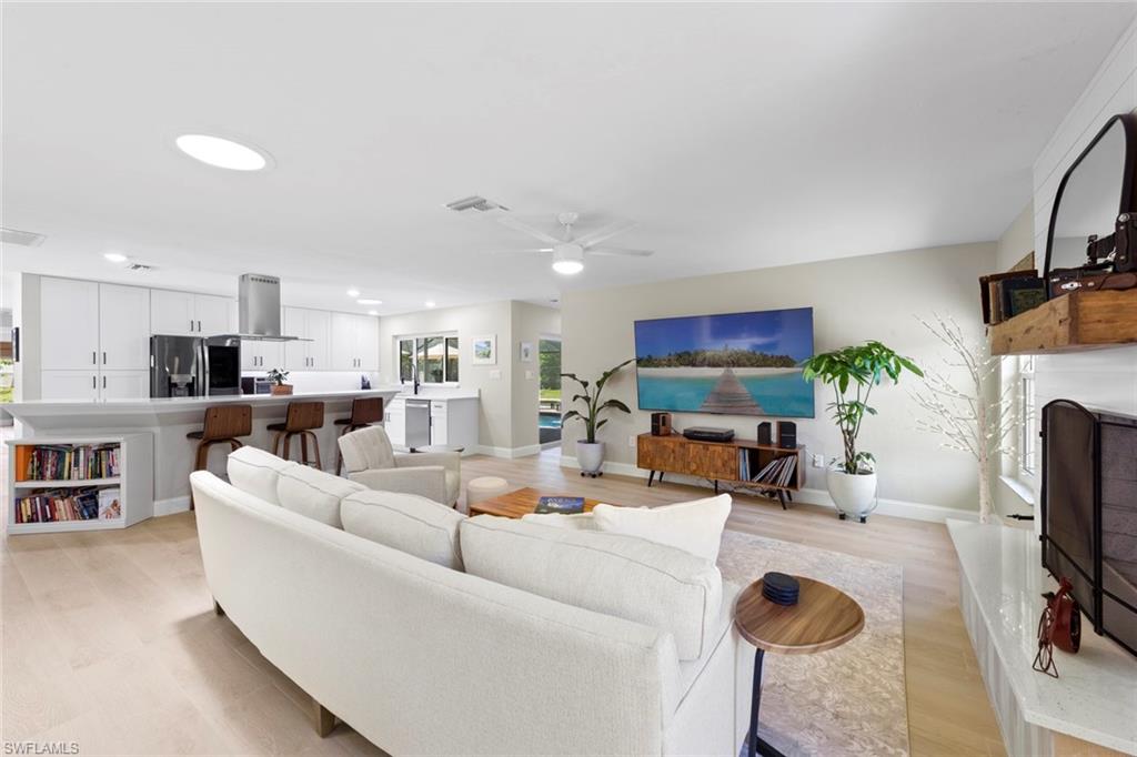 3795 Liberty Square Fort Myers, FL 33908 - Photo 11 of 43 a living room with furniture a flat screen tv and kitchen view