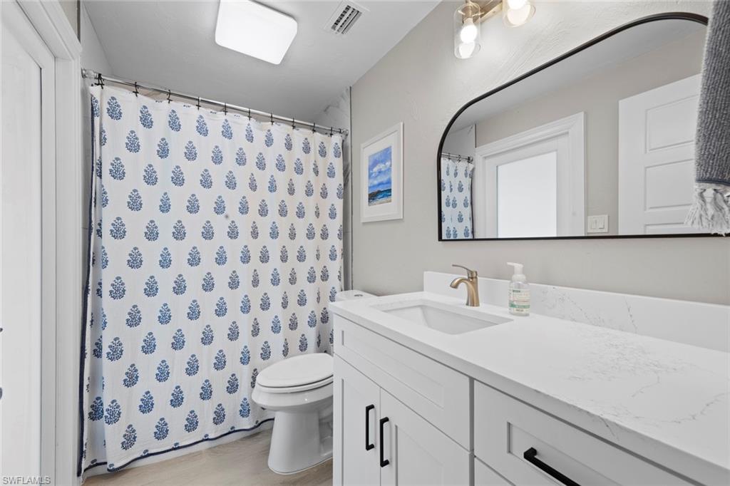 3795 Liberty Square Fort Myers, FL 33908 - Photo 30 of 43 a bathroom with a sink a toilet and shower curtain