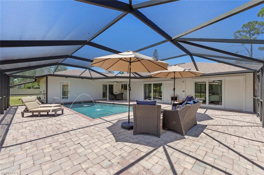 3795 Liberty Square Fort Myers, FL 33908 - Photo 33 of 43 a patio with a table and chairs under an umbrella
