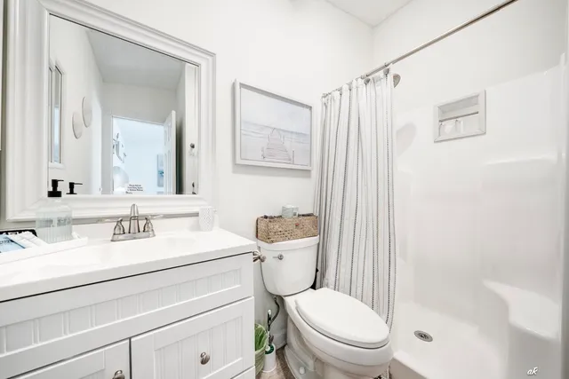 a bathroom with a sink a toilet a mirror and shower