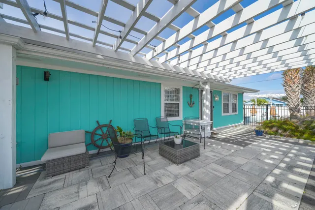 a view of a patio with table and chairs and wooden fence