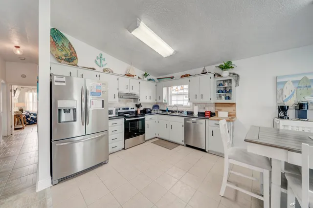 a kitchen with white cabinets and stainless steel appliances