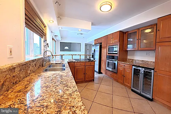 a large kitchen with stainless steel appliances granite countertop a stove and a sink