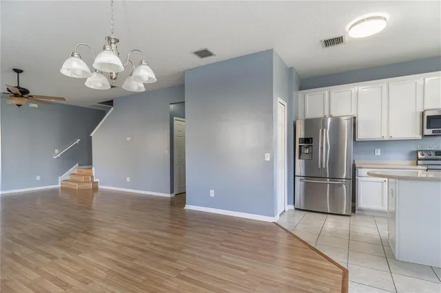 a view of a kitchen with a microwave and a chandelier