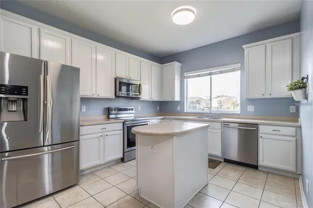 a kitchen with granite countertop appliances cabinets and a sink