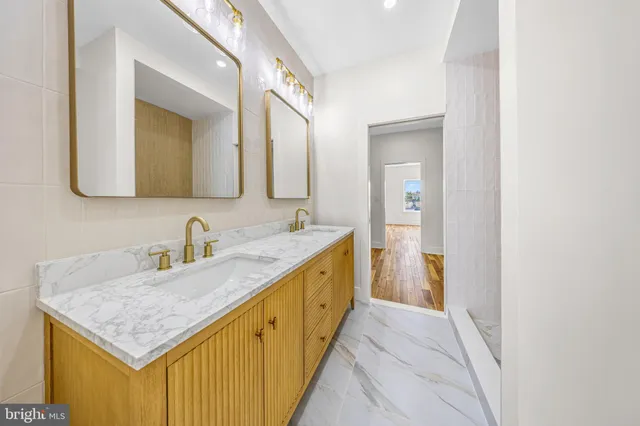 a bathroom with a granite countertop sink a mirror and shower