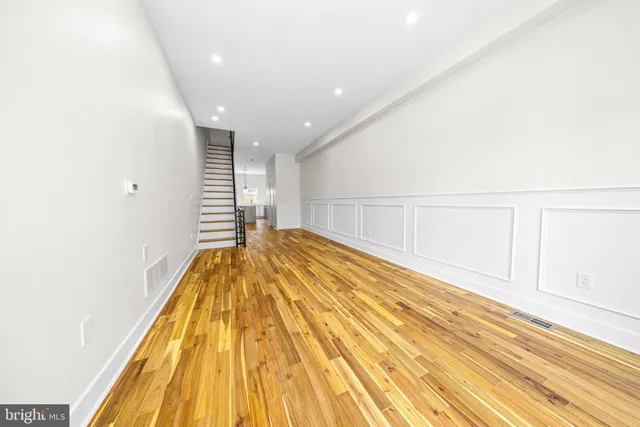 a view of a hallway with wooden floor and staircase