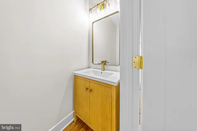 a kitchen with kitchen island wooden floors appliances and cabinets