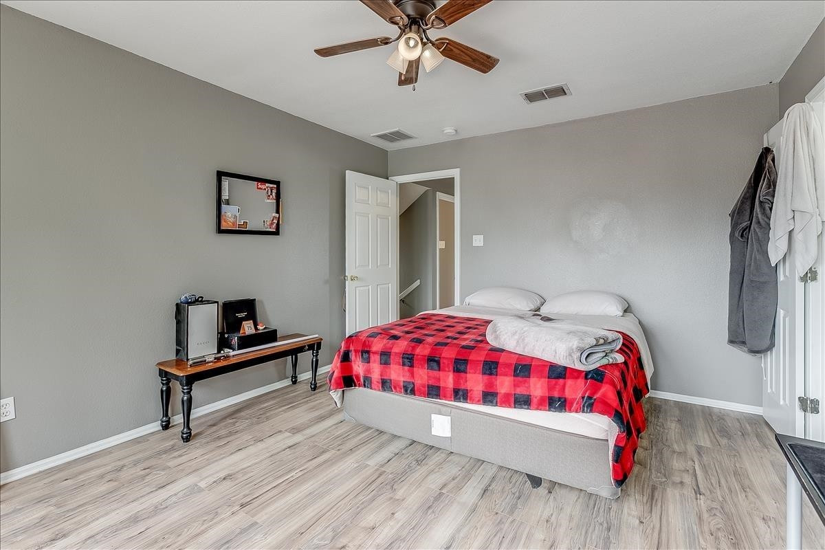 5307 69th Street Lubbock, TX 79424 - Photo 17 of 22 a bedroom with a bed and a dresser with wooden floor