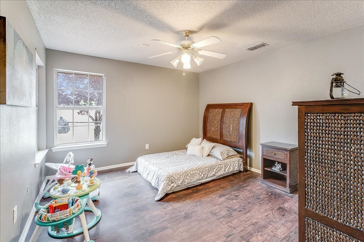 5307 69th Street Lubbock, TX 79424 - Photo 18 of 22 a bedroom with a bed and ceiling fan