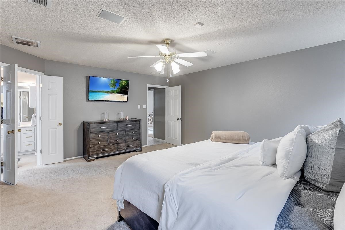 5307 69th Street Lubbock, TX 79424 - Photo 8 of 22 a spacious bedroom with a bed and a tv