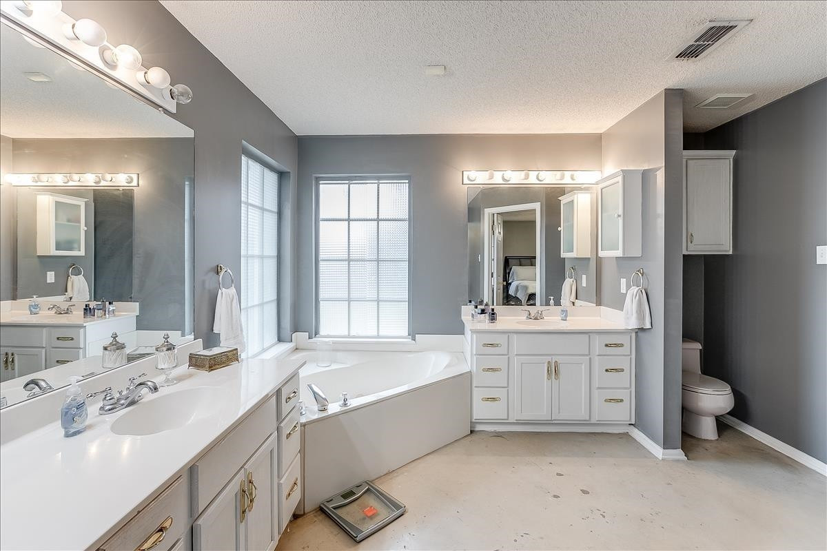 5307 69th Street Lubbock, TX 79424 - Photo 9 of 22 a large bathroom with a double vanity sink a large mirror and a bathtub