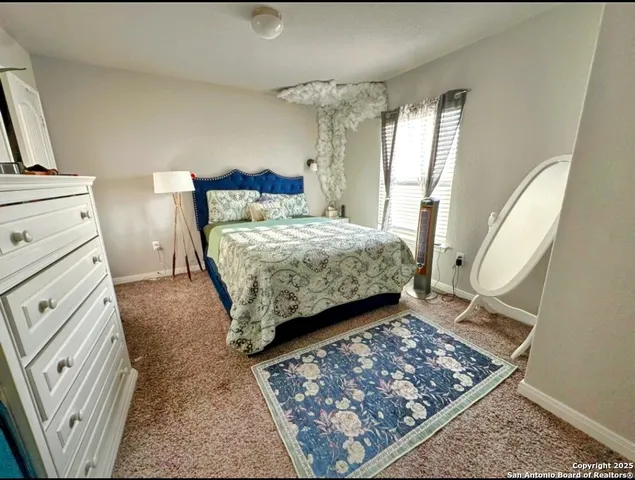 a bedroom with a bed rug and wooden floor