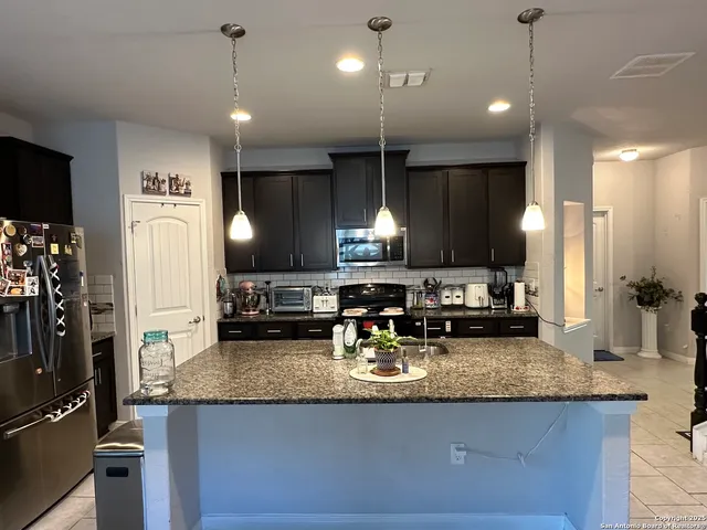 a kitchen with sink stove and refrigerator