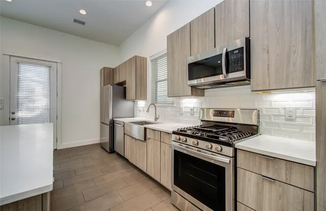 a kitchen with stainless steel appliances a refrigerator sink and cabinets