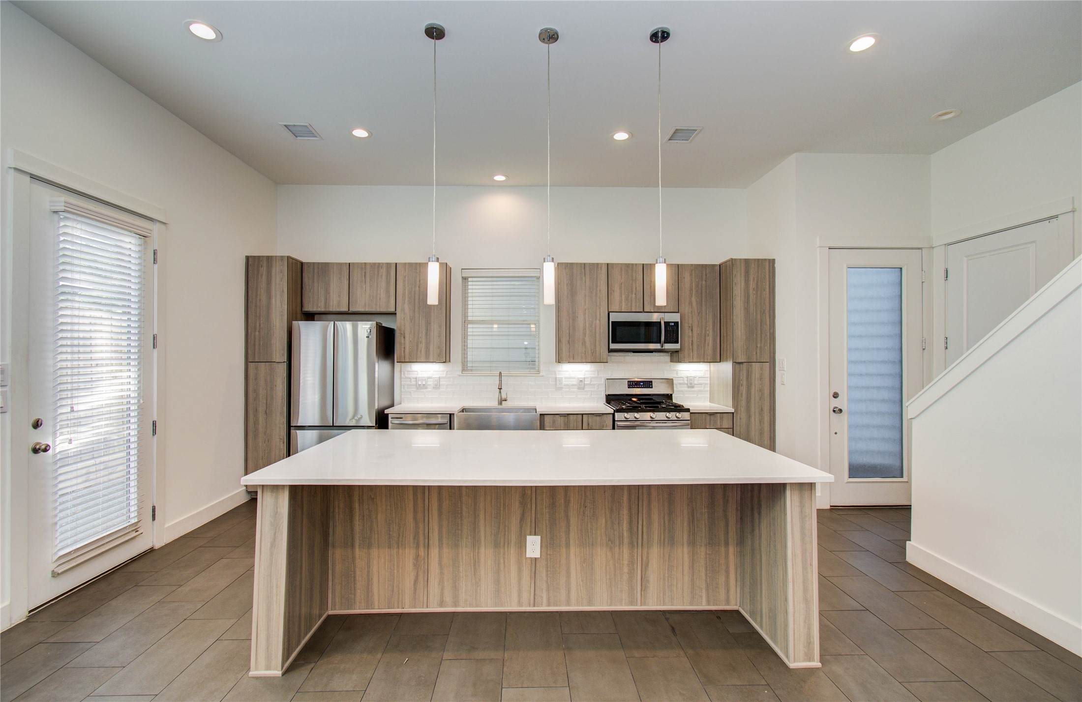 556 Janisch Road Houston, TX 77018 - Photo 9 of 29 a large kitchen with kitchen island a large counter top stainless steel appliances and cabinets