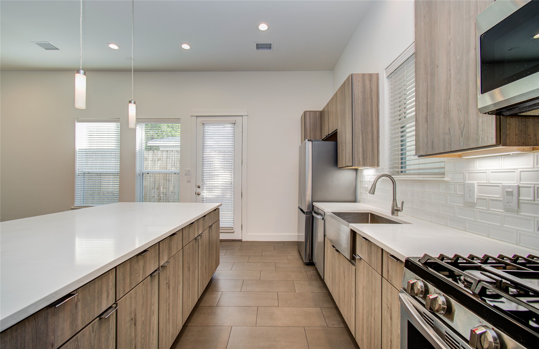 556 Janisch Road Houston, TX 77018 - Photo 10 of 29 a kitchen with stainless steel appliances sink stove microwave and cabinets