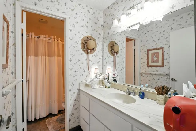 a bathroom with a granite countertop sink and a mirror