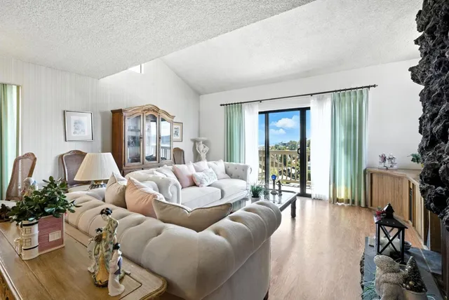 a living room with furniture large window and wooden floor