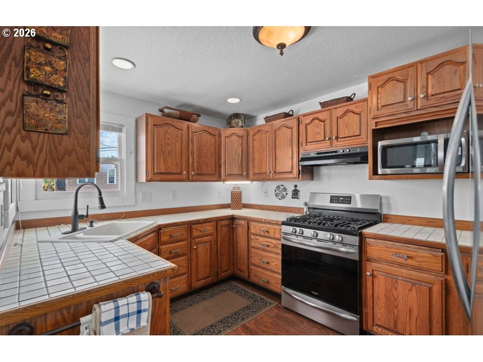 406 West C Street Rainier, OR 97048 - Photo 20 of 48 a kitchen with stainless steel appliances granite countertop a stove sink and cabinets