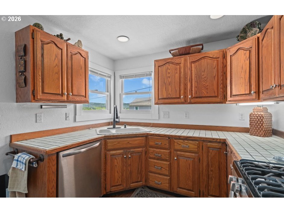 406 West C Street Rainier, OR 97048 - Photo 21 of 48 a kitchen with stainless steel appliances granite countertop a sink dishwasher stove and cabinets