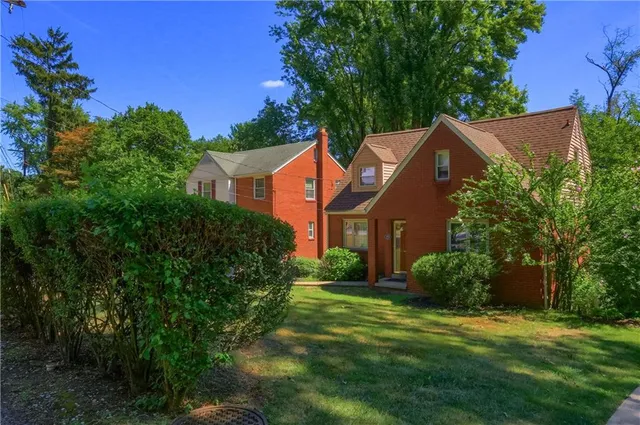 a front view of house with yard and green space