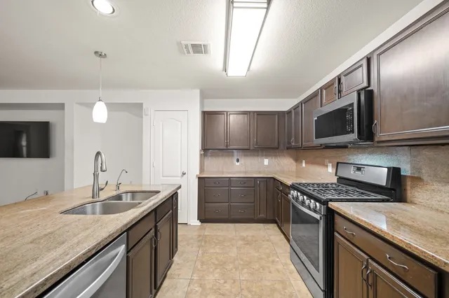 a kitchen with stainless steel appliances granite countertop a sink and stove top oven