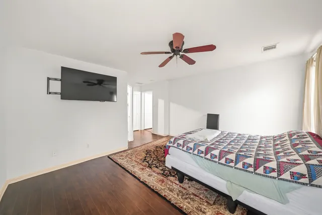 a bedroom with a bed a flat screen tv and a window