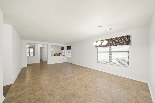 an empty room with windows and cabinet