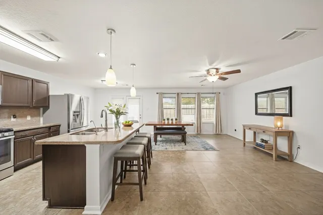 a kitchen with cabinets a sink stainless steel appliances and dining table