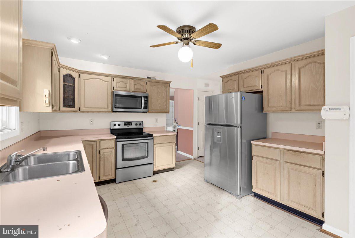 5789 Greenock Road Lothian, MD 20711 - Photo 14 of 57 a kitchen with stainless steel appliances granite countertop a refrigerator a stove a microwave oven with a sink and dishwasher