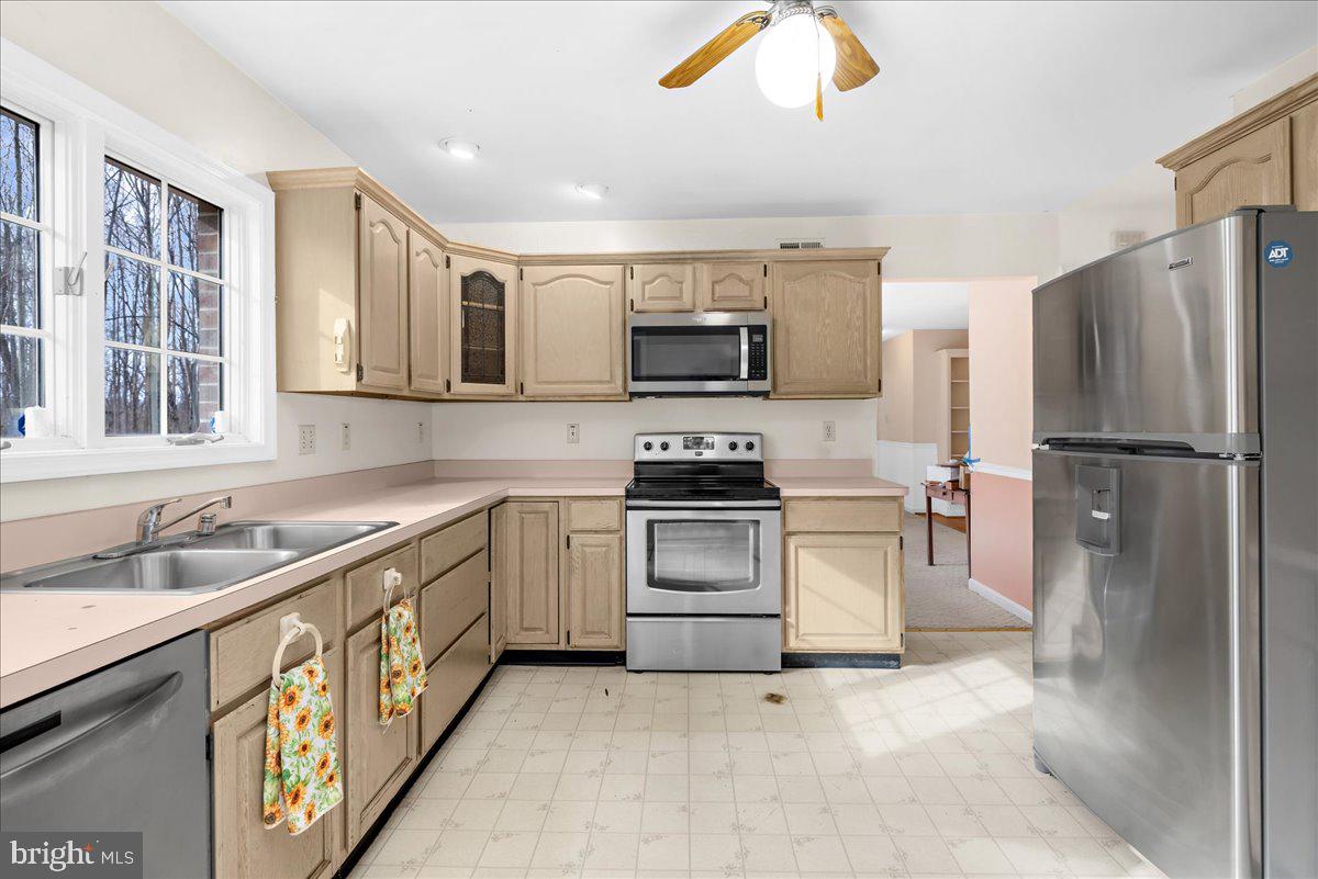 5789 Greenock Road Lothian, MD 20711 - Photo 15 of 57 a kitchen with granite countertop a sink stainless steel appliances and cabinets