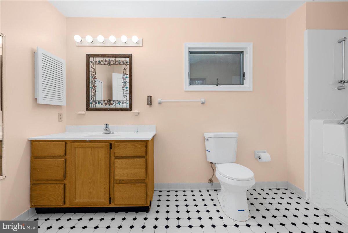5789 Greenock Road Lothian, MD 20711 - Photo 26 of 57 a bathroom with a sink a toilet and mirror