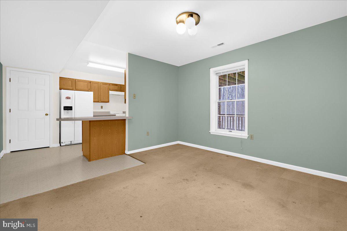 5789 Greenock Road Lothian, MD 20711 - Photo 40 of 57 an empty room with a kitchen space and wooden floor