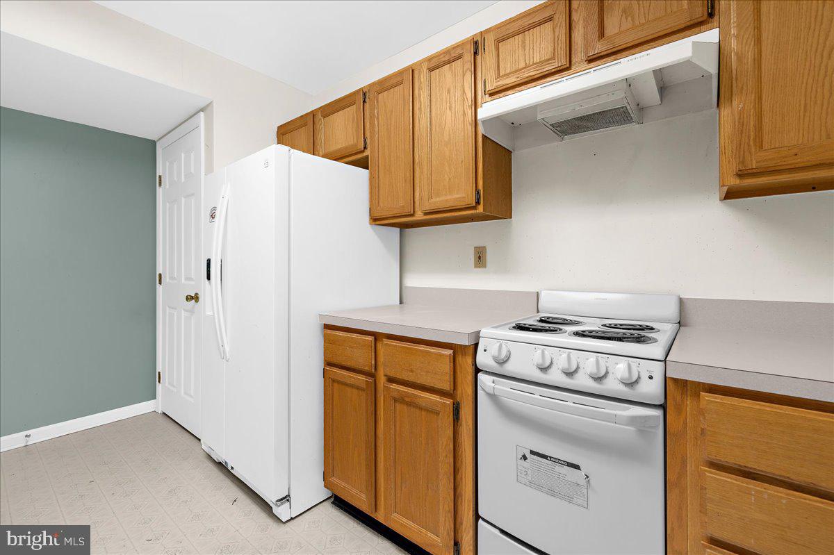 5789 Greenock Road Lothian, MD 20711 - Photo 46 of 57 a kitchen with white cabinets and white appliances