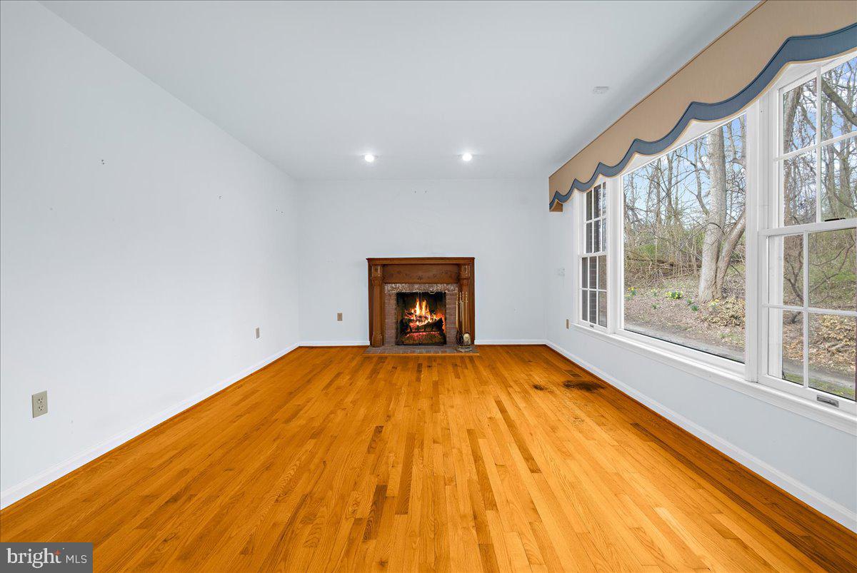 5789 Greenock Road Lothian, MD 20711 - Photo 6 of 57 a view of an empty room with a window and wooden floor