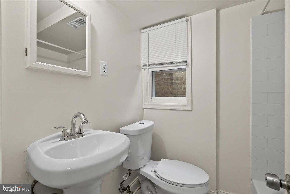 6416 Blair Road Northwest Washington, DC 20012 - Photo 23 of 32 a bathroom with a toilet a sink and mirror
