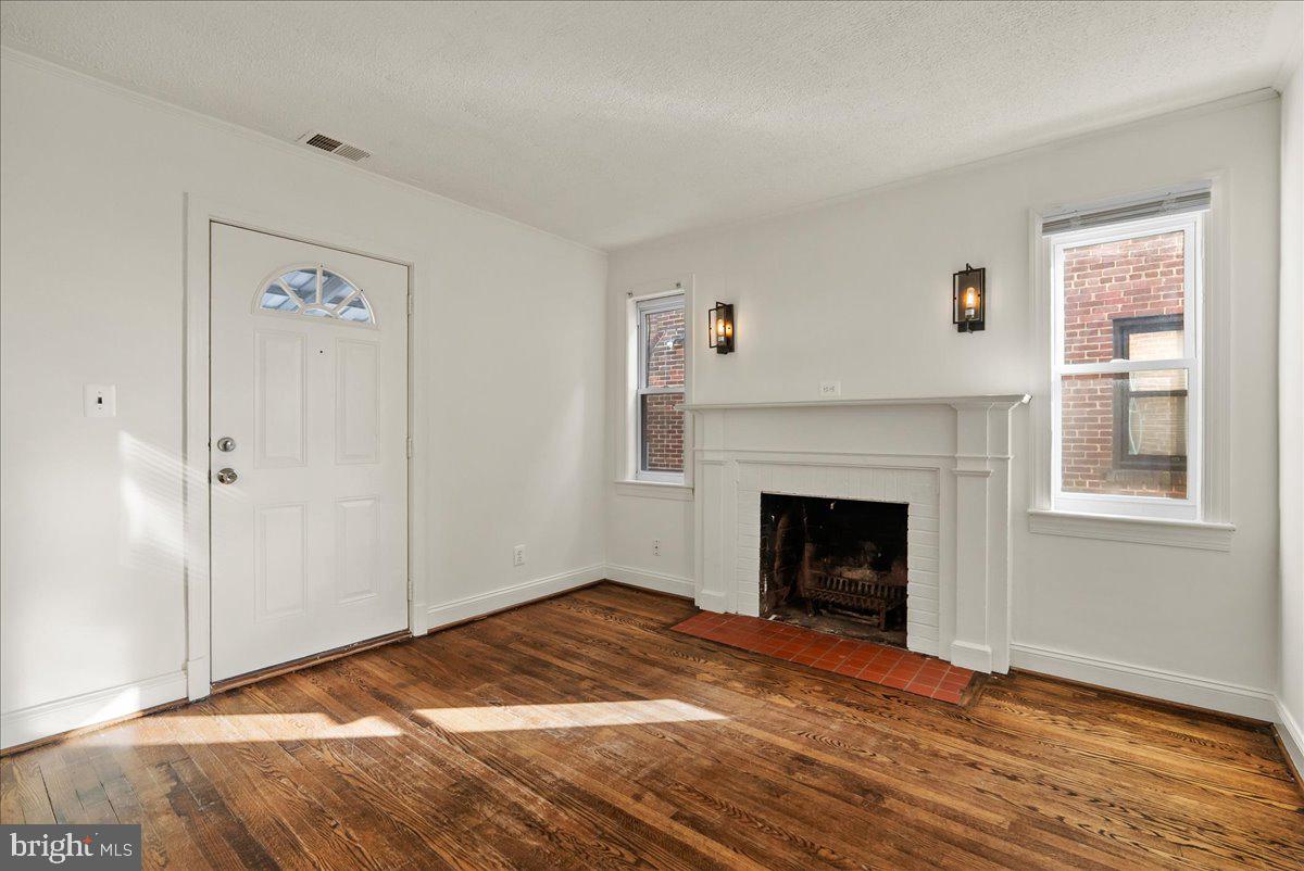 6416 Blair Road Northwest Washington, DC 20012 - Photo 6 of 32 a view of empty room with wooden floor and fireplace