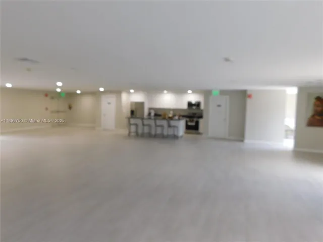 a view of a big room with chandelier fan and windows