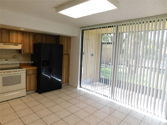 a kitchen with a refrigerator and white cabinets