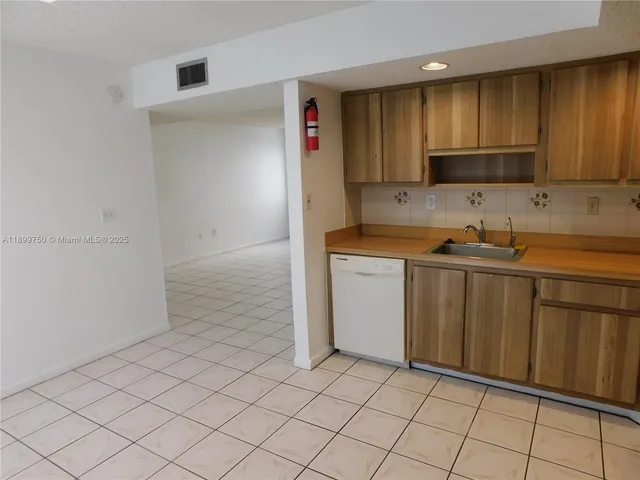 a kitchen with a sink cabinets and appliances