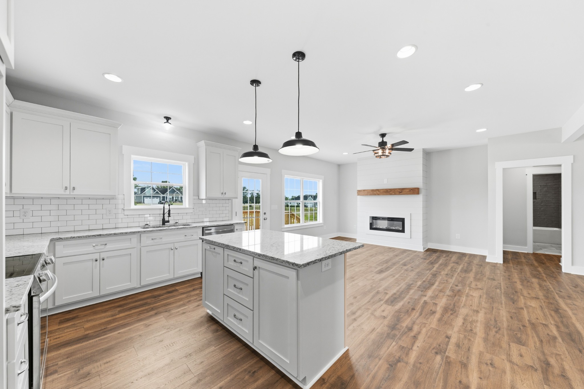 338 Dugout Road Summertown, TN 38483 - Photo 29 of 75 a large kitchen with granite countertop a stove oven and white cabinets with wooden floor