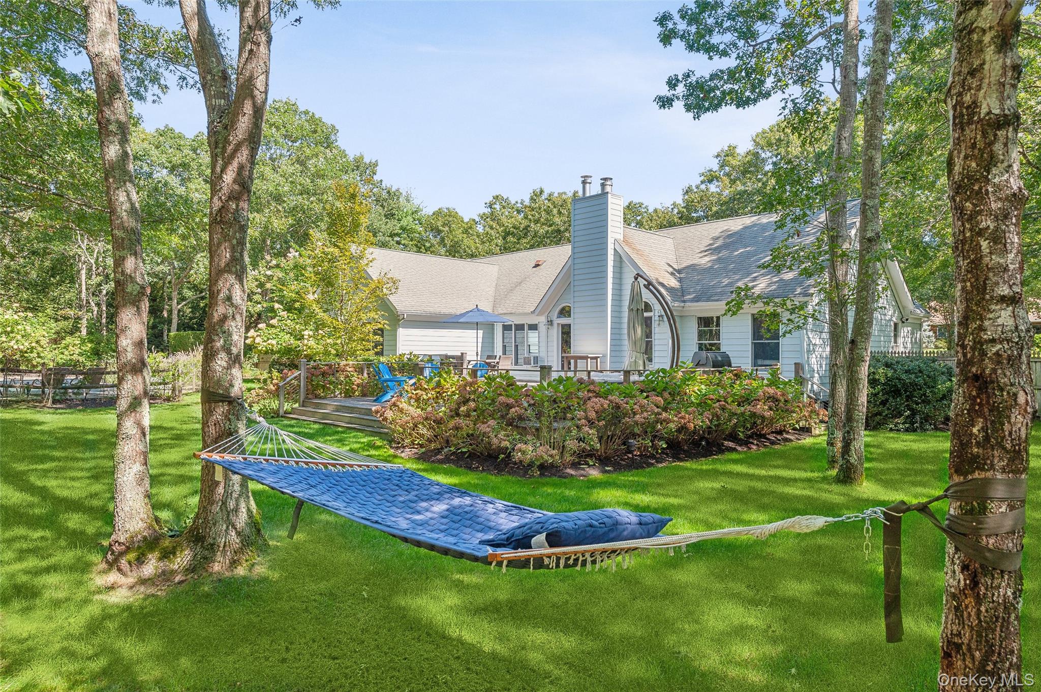14 Hildreth Road Hampton Bays, NY 11946 - Photo 24 of 29 Rear view of house with a chimney, a shingled roof, and a lawn