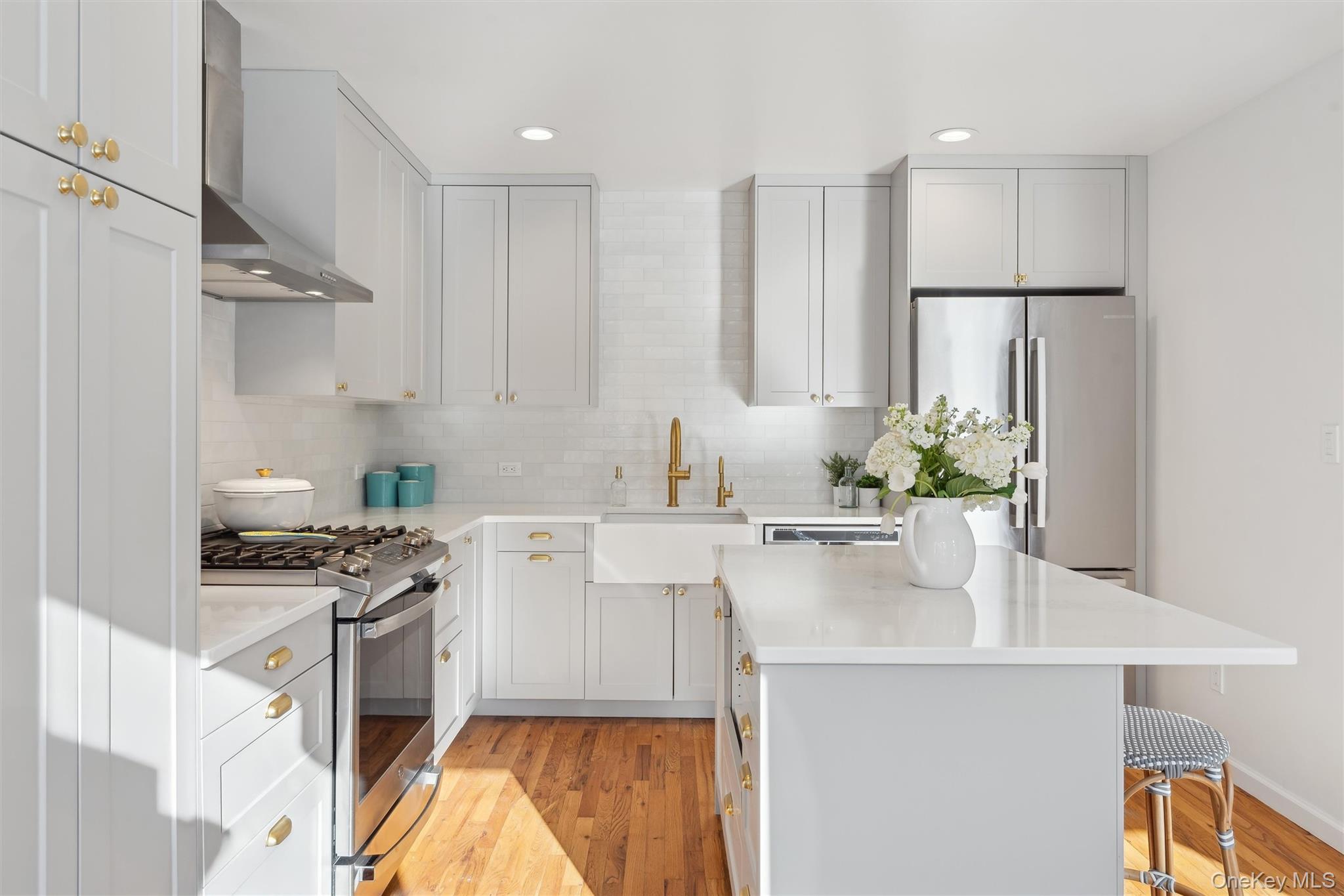 14 Hildreth Road Hampton Bays, NY 11946 - Photo 9 of 29 Kitchen featuring stainless steel appliances, a kitchen island, a sink, wood flooring, and wall chimney range hood