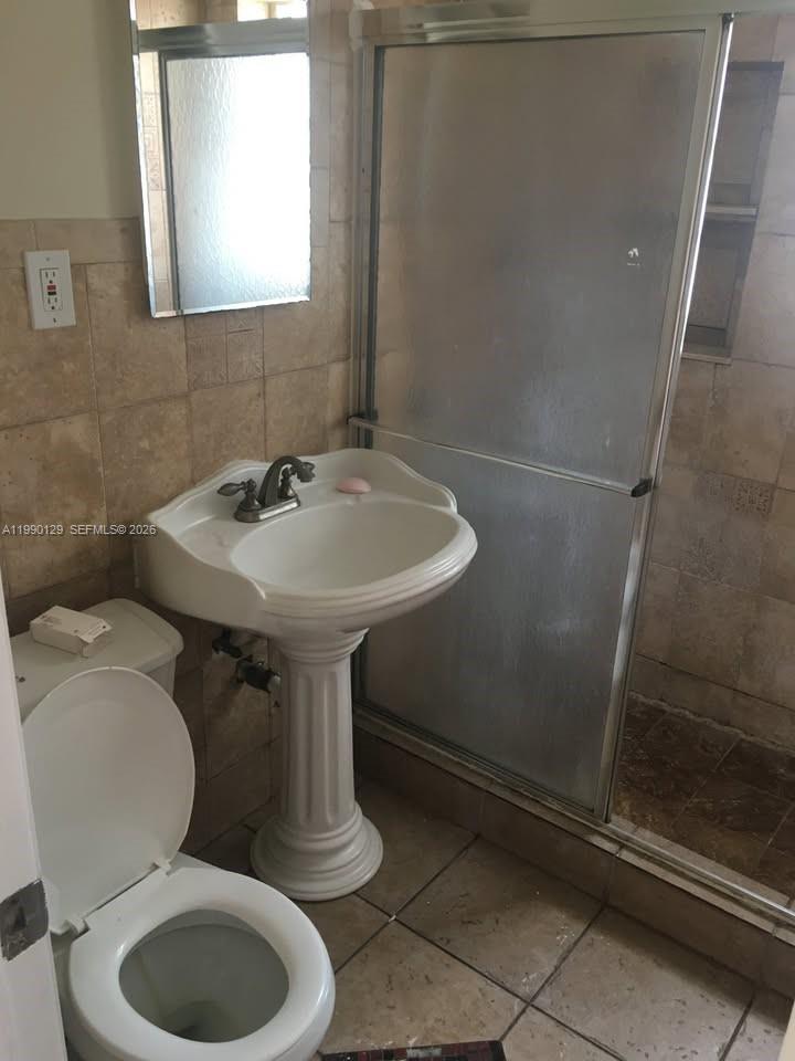 625 East 8th Court Hialeah, FL 33010 - Photo 12 of 18 a bathroom with a toilet sink and mirror